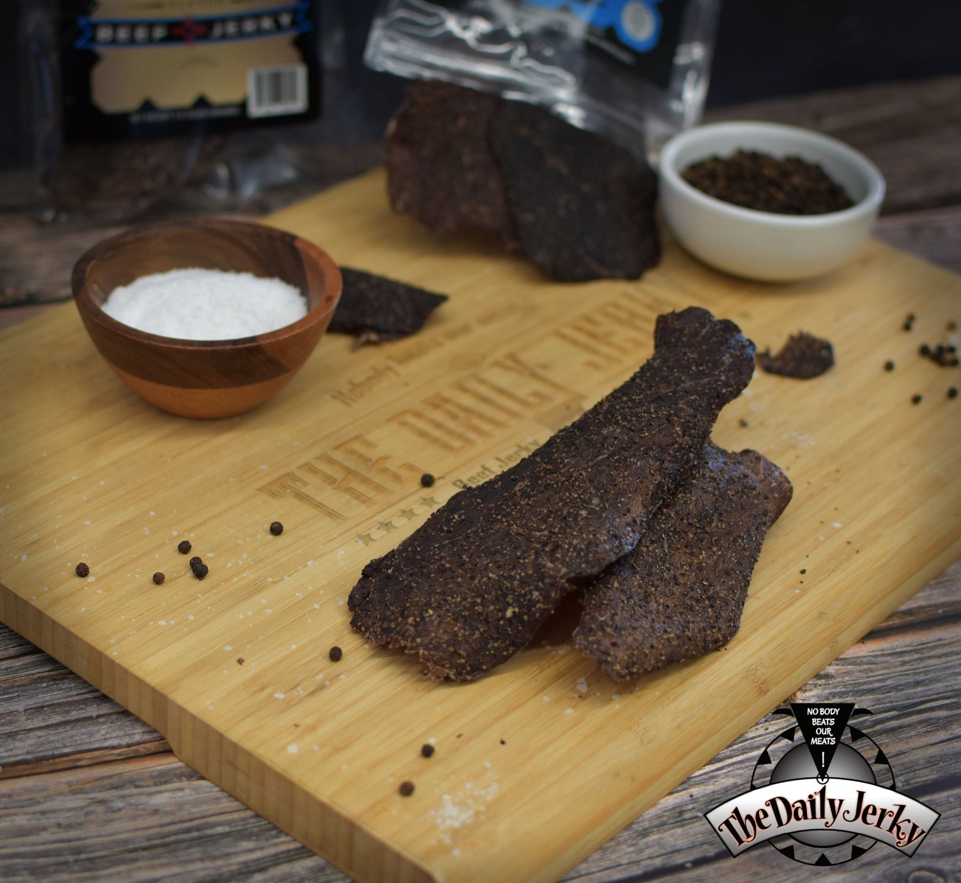 Salt and pepper beef jerky from The Daily Jerky in a simple classic setting on a wooden board 