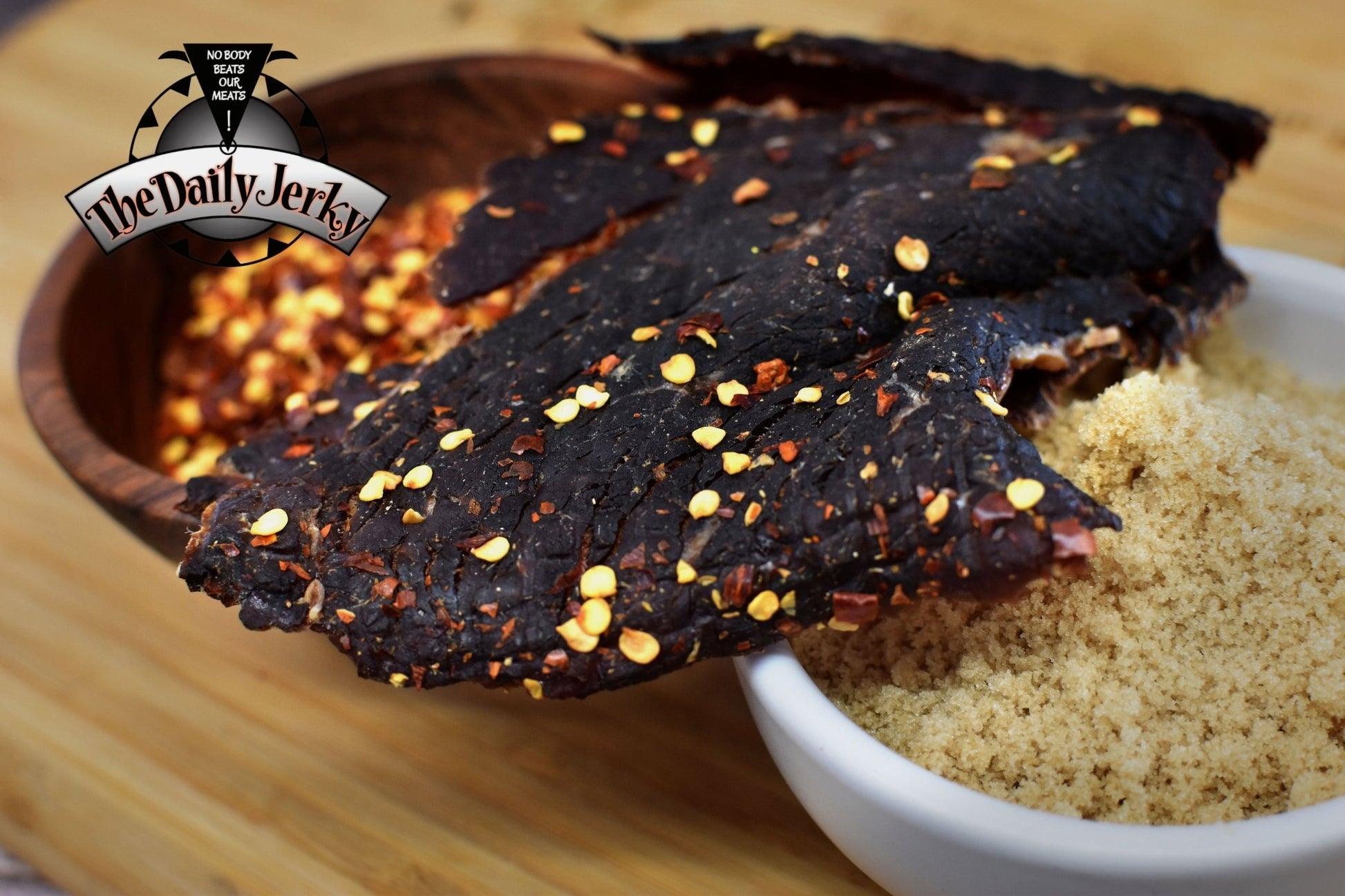 Close up of spicy teriyaki beef jerky pieces from The Daily Jerky showing glossy teriyaki coating stacked on top of bowls