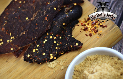 Close up of spicy teriyaki beef jerky pieces from The Daily Jerky showing pieces stacked on top of each other