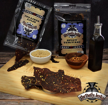 Bags of The Daily Jerky spicy teriyaki beef jerky arranged with teriyaki sauce and chile peppers and brown sugar 